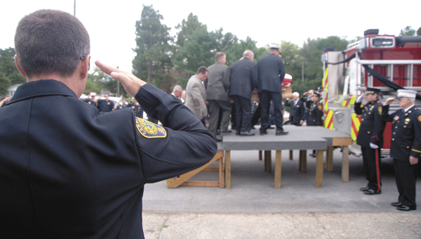 Above, firefighters salute as the casket of William G. “Jerry” Saunders is loaded onto Engine 29 of Chuckatuck Volunteer Fire Department, where he was a 60-year volunteer, 17 years as chief. (Matthew Walker photo)